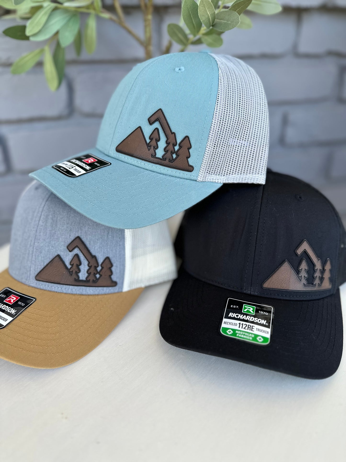 Trucker hat with mountain and trees leather patch